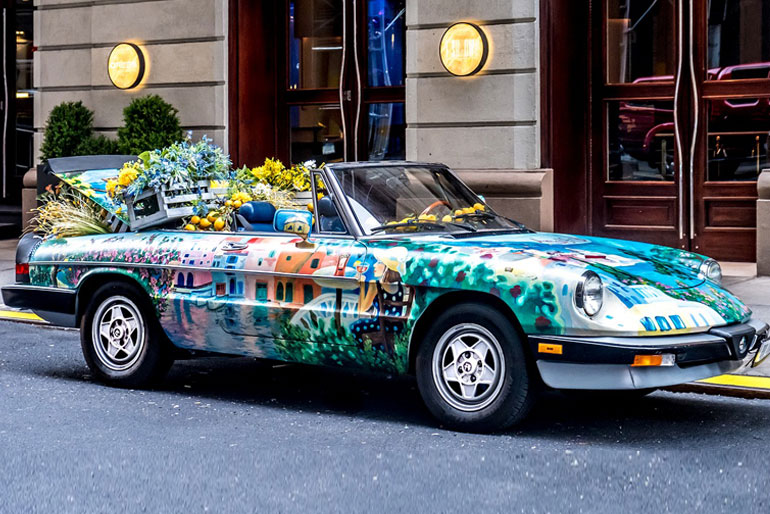 A very colorful convertible in the middle of the street with a lot of colorful things.